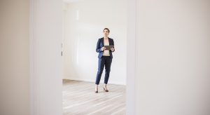 Woman in empty apartment with tablet