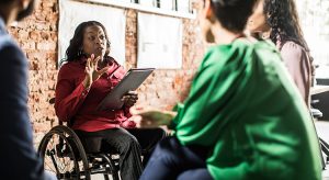 Businesswoman in wheelchair leading group discussion in creative office