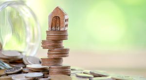 Tiny house model on top of stack of coins
