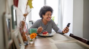 Mature woman eating breakfast and having video call