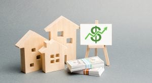 Wooden figures of houses and a poster with money