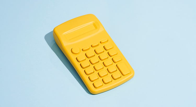Elevated view of yellow calculator on a blue colored background