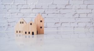 Building different miniature wooden houses on a white background.