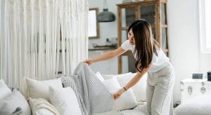 woman fixing her throw pillow in the sofa