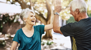 Older man and woman high-fiving each other