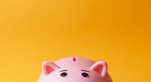 Yellow background with part of a pink "piggy" bank