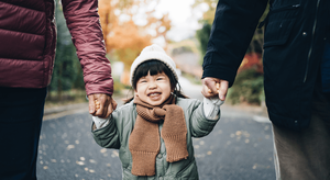 Child holding hands and walking in winter clothes