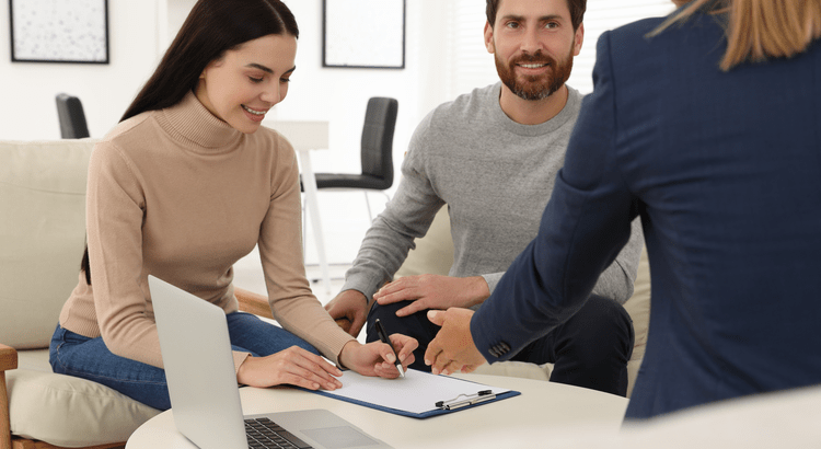 man and woman reviewing paperwork with their agent