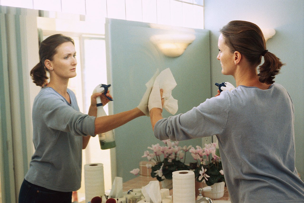 Woman cleaning a mirror