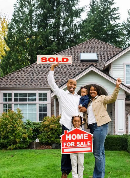 Family in front of home with a sold sign