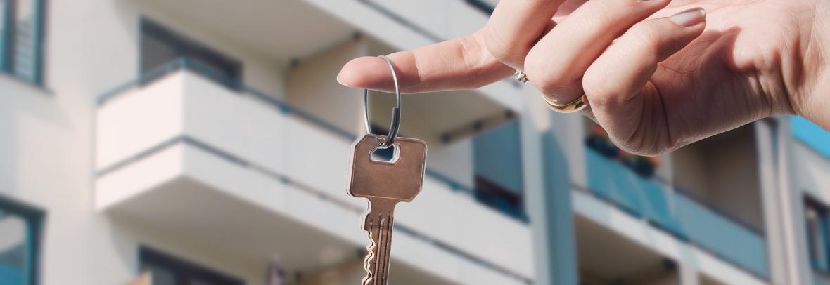 Holding a Key with a Condo Highrise in the Background