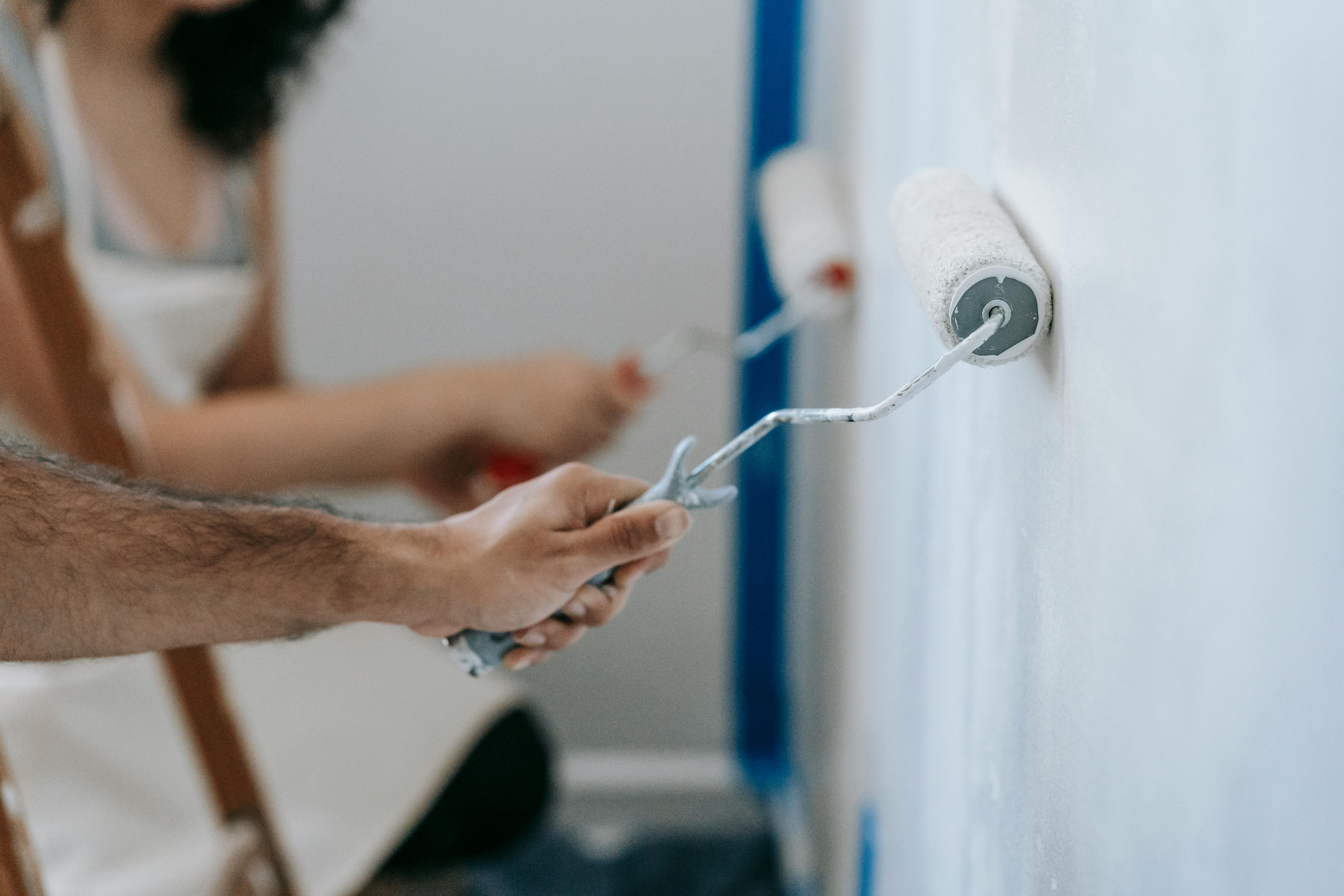 Two People Painting The Wall