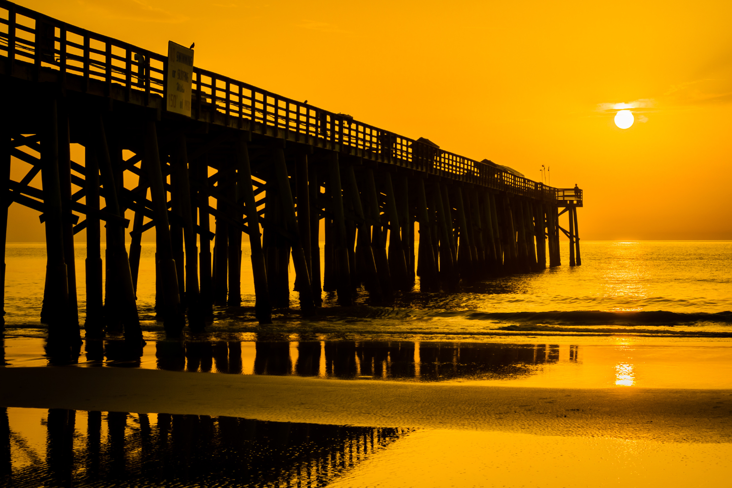 Best Realtor Flagler Beach Picture shows Flagler pier with a golden sunrise.