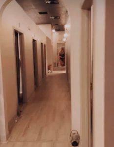 BLB Luxury Treatment rooms hallway shown with beige walls and wood flooring.