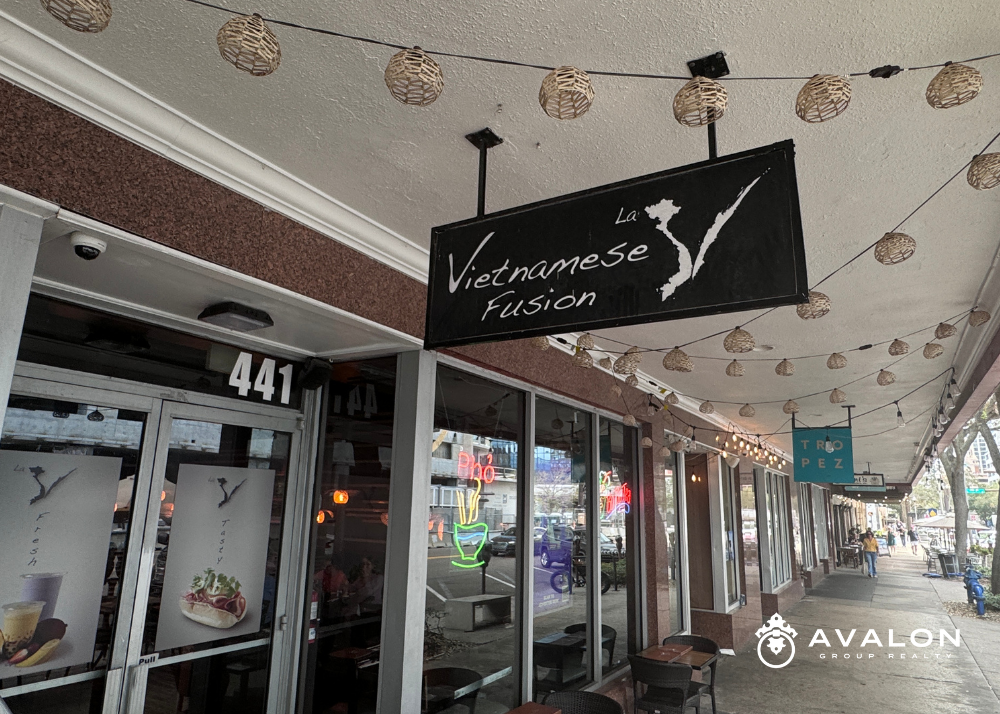 Located across the street from the Residences, the new tallest building on the west coast of Florida.. The store sign is black with white letters.