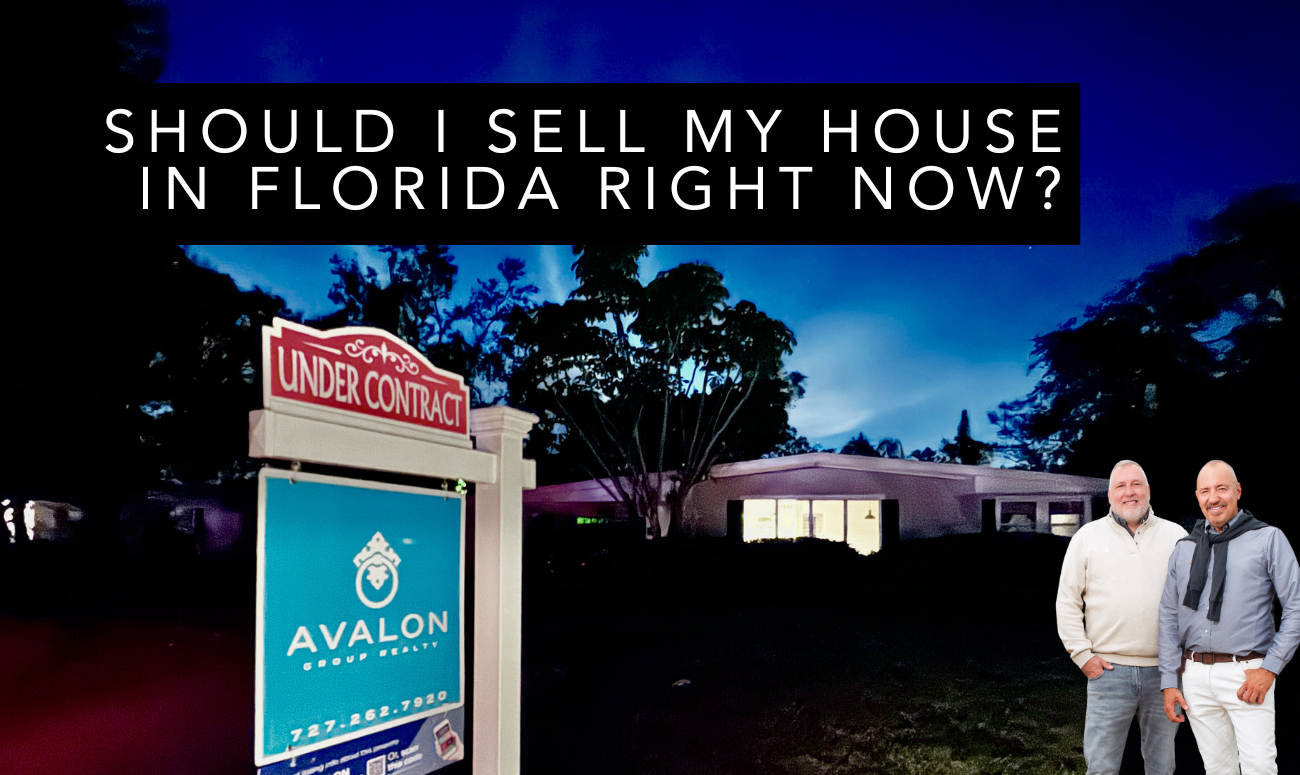 Should I Sell My House in Florida Right Now picture shows a house that just went under contract with the Avalon Group Realty for sale sign in the yard. The sign is aqua blue and red.