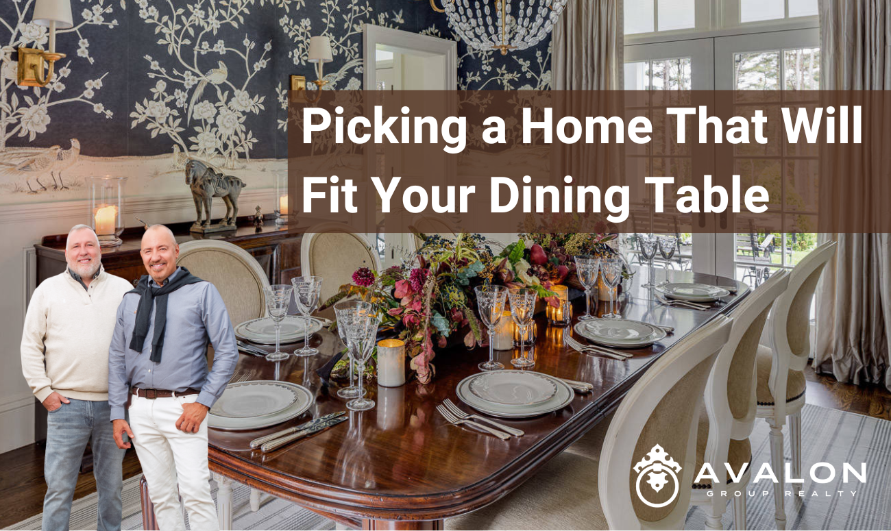 Picking a Home That Will Fit Your Dining Table picture shows a dining room with a brown wood table with wallpaper on walls that is navy blue with white vines.