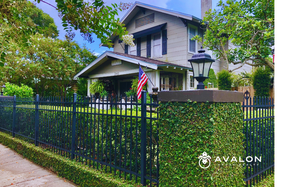 Historic Home Ownership in Kenwood & Old Northeast picture shows a historic home that is beige and brown, with a wrought iron and brick fence covered in ivy.