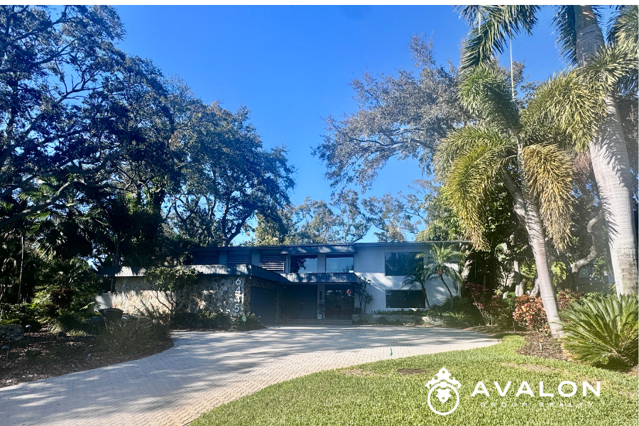 Modern waterfront home surrounded by mature oak trees and tropical landscaping in the Pasadena Lakes neighborhood of St. Petersburg Florida