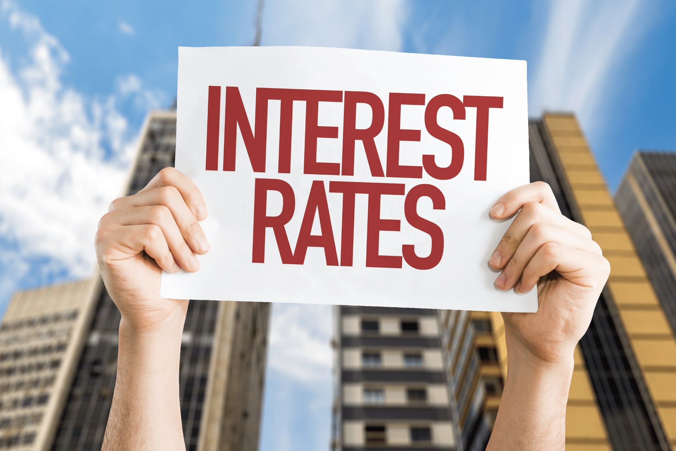 Interest rates sign being held up in front of a building.
