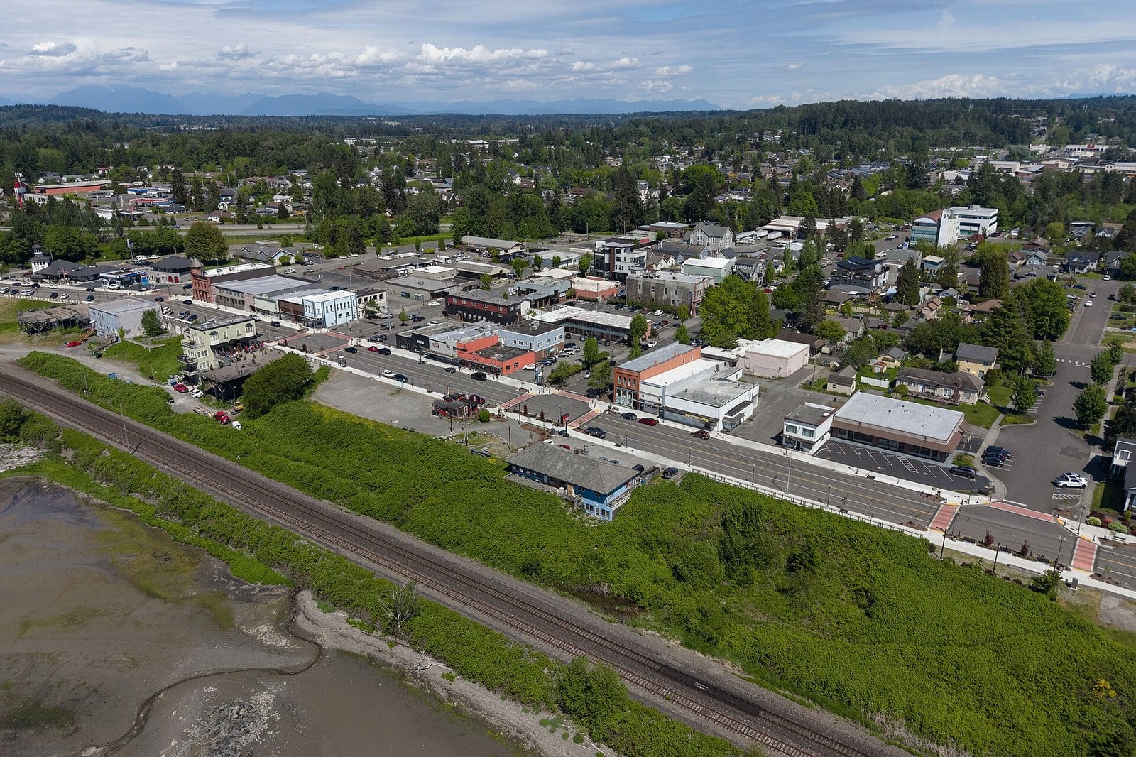 Aerial view of downtown Blaine, Washington, with the waterfront rail line and tide flats in the foreground and mountains on the horizon
