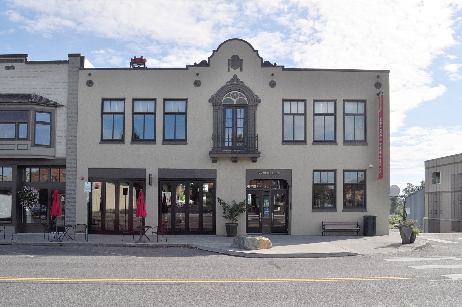 The two-story Jansen Art Center on Front Street in Lynden, a cream-colored former city hall with an ornate arched balcony window above the entrance and a red Jansen Art Center banner