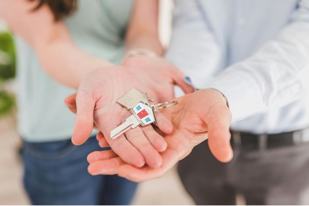 Homebuyers holding keys to their new home.