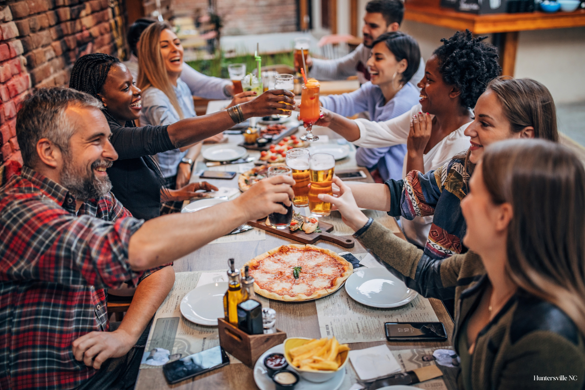 Friends enjoying dinner on an outdoor restaurant patio in Huntersville, North Carolina