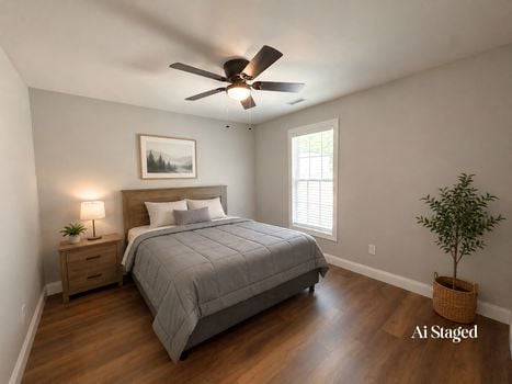 AI staged primary bedroom with luxury vinyl plank flooring and large window in Chester SC home.