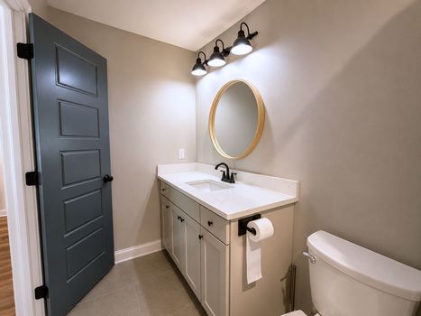 Primary bathroom vanity with modern lighting and solid surface countertop in Chester SC home.