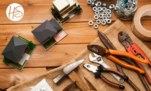 Assorted tools sitting on a wood table with model homes