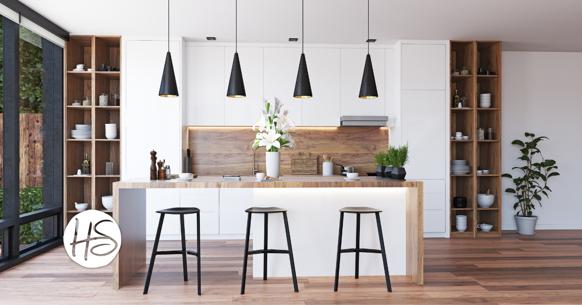 A modern kitchen with white cabinetry, wooden accents, open shelving, black pendant lighting, and a spacious island with bar stools, staged to create an inviting atmosphere.