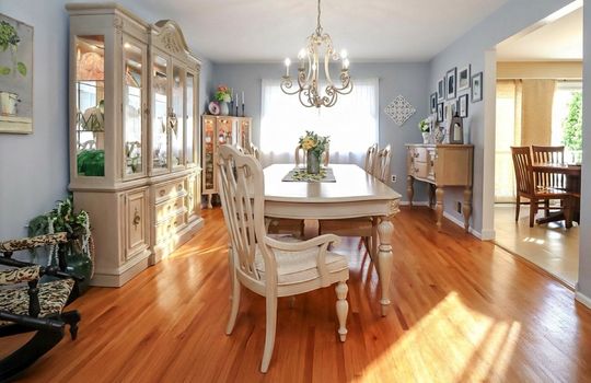 Beautiful formal dining room with sun-drenched hardwood floors, classic chandelier, and generous entertaining space in desirable Tottenville, Staten Island.