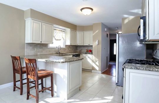 Bright kitchen with white cabinetry, tile flooring, and a functional layout for everyday living.