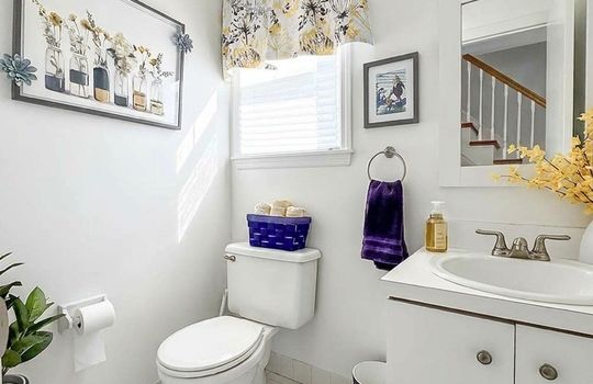 First-floor half bath with vanity, natural light, and tile flooring.
