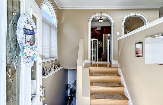 Foyer area with wood stairs and porcelain tile