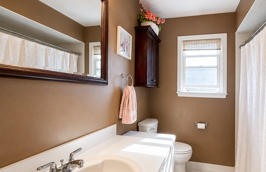 Full bathroom with oversized vanity, tub and shower combination, tile flooring, and natural light in a Tottenville Staten Island home.