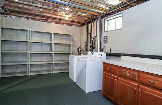 Functional basement laundry room with utility workspace, and additional organization space in desirable Tottenville, Staten Island.