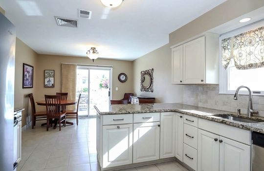 Gather with family and friends in this bright eat-in kitchen offering granite counters, ample workspace, stainless steel appliances, and easy access to outdoor living spaces.