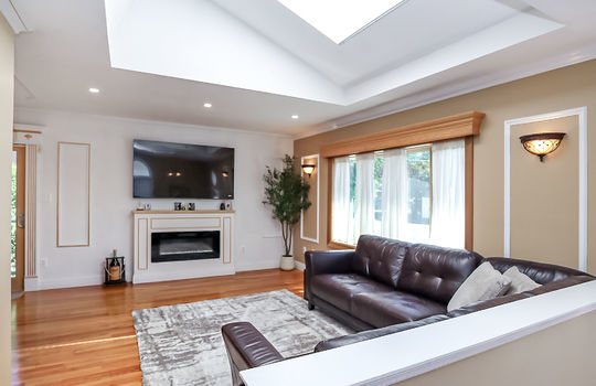 Living room with hardwood floors and skylight