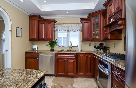 Updated kitchen with custom cabinetry, granite countertops, and stainless steel appliances