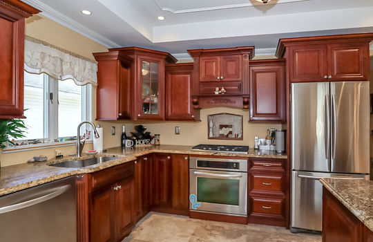 Updated kitchen with custom cabinetry, granite countertops, and stainless steel appliances in Prince's Bay home