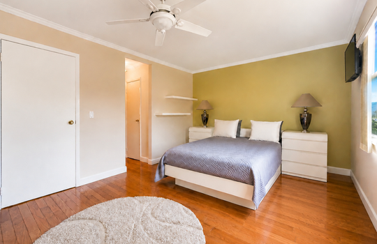 Primary bedroom with hardwood floors and generous closet space in Grasmere condo