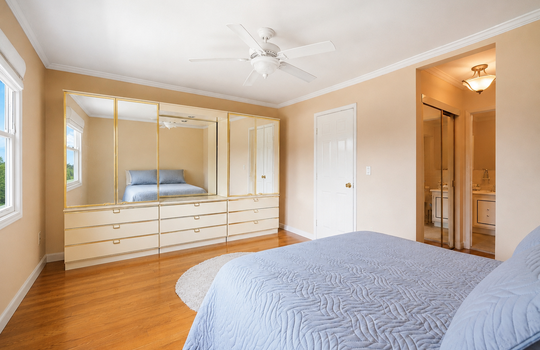 Primary bedroom with hardwood floors and generous closet space in Grasmere condo
