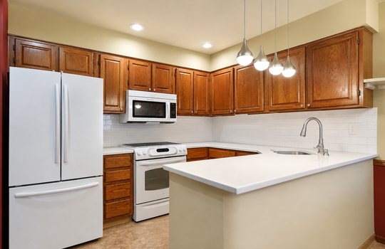 Updated kitchen with wood cabinetry and stainless steel appliances in Grasmere condo