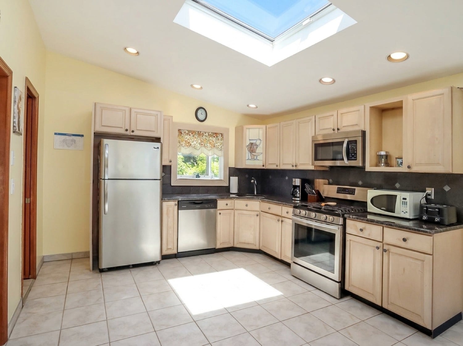 Kitchen at 34 Church Avenue with light cabinetry, stainless steel appliances, and a skylight.