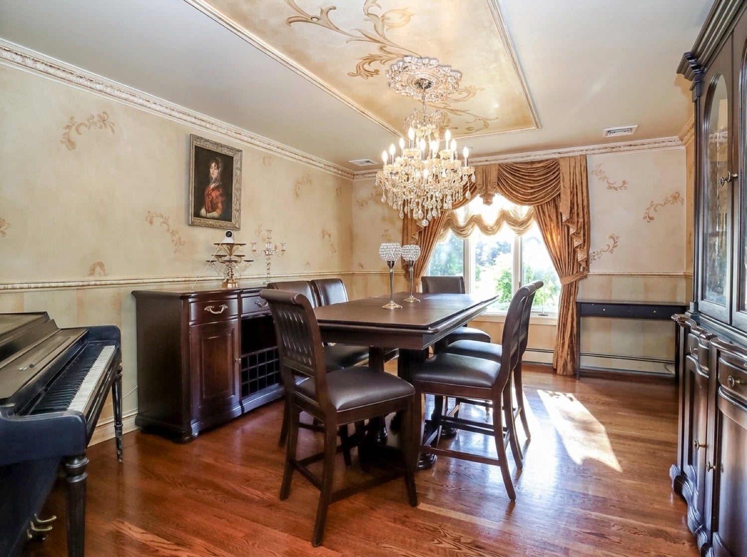 Formal dining room at 34 Fayann Lane featuring hardwood floors, crystal chandelier and decorative ceiling details