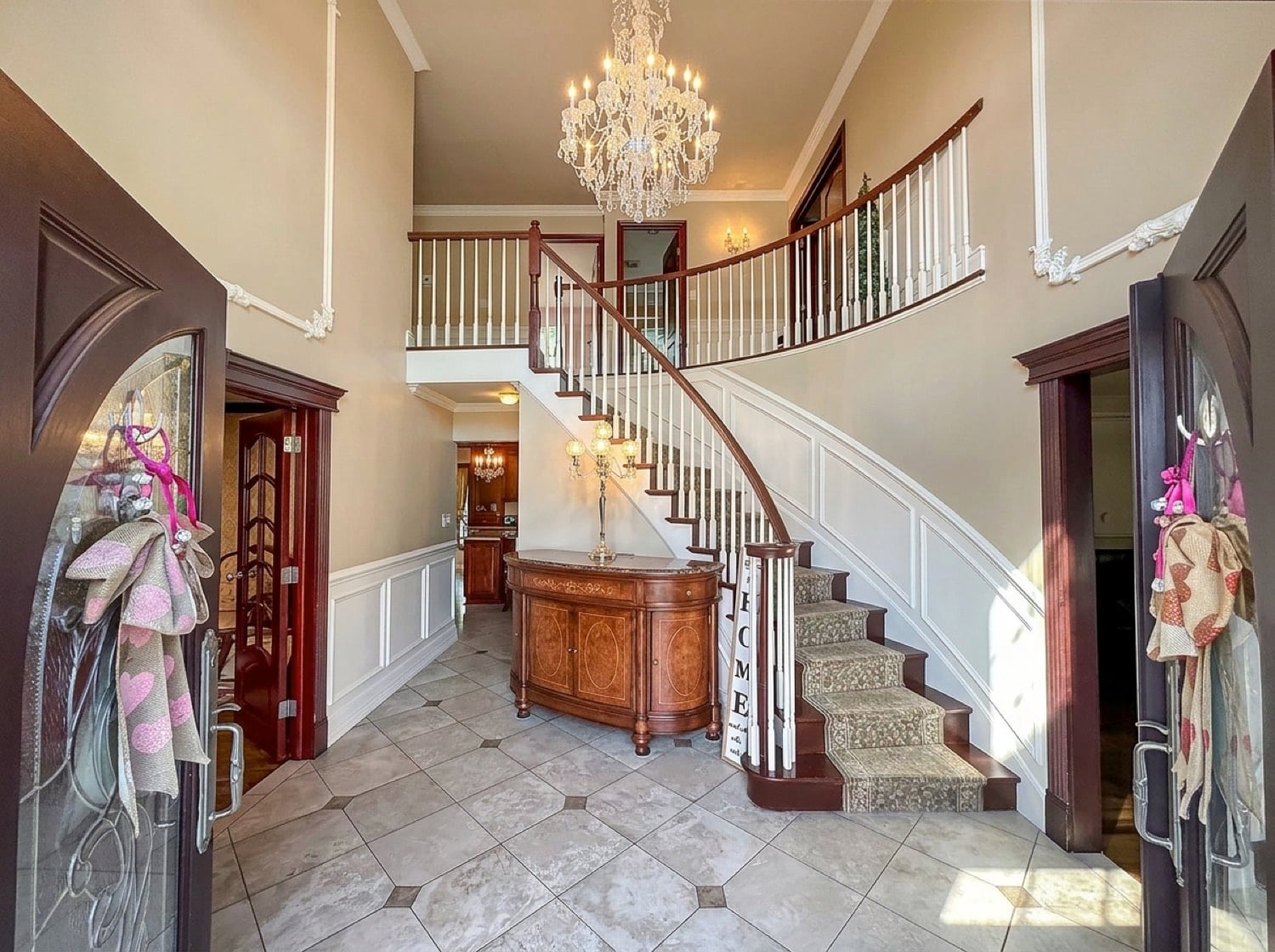Grand two-story entry foyer at 34 Fayann Lane in Tottenville with a sweeping mahogany staircase and travertine flooring