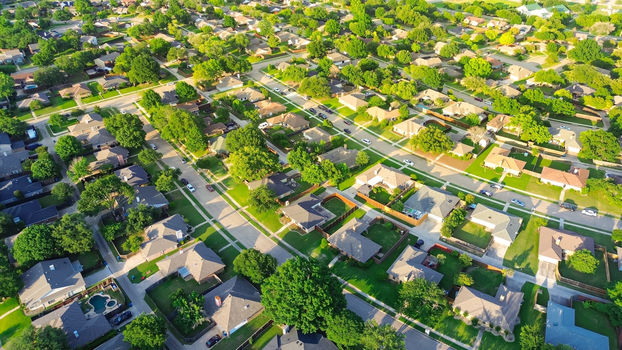 Parallel residential streets with back alleys and row of single-family houses surrounding by lush green trees in suburbs Dallas Fort Worth metro complex, suburban homes swimming pool, aerial. USA
