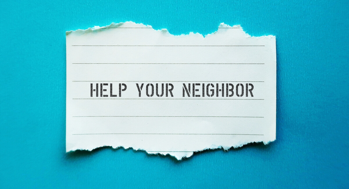 Help your neighbor written on a ripped piece of notepad paper on a blue background